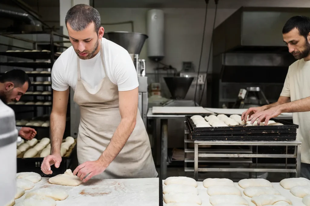 Panaderos amasando pan en una panadería industrial